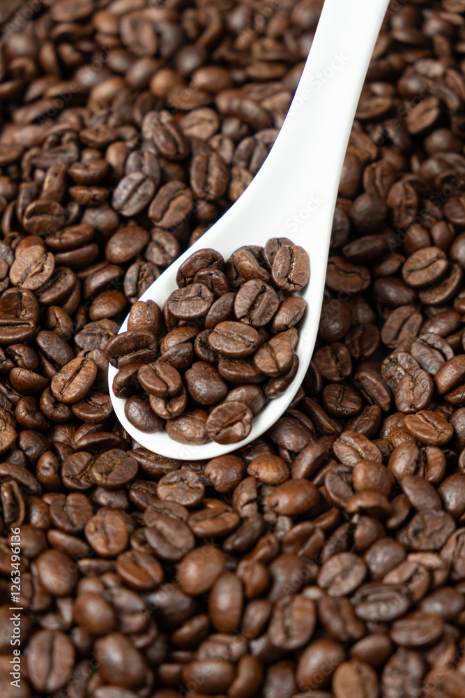 Freshly roasted coffee decaffeinated beans in a spoon close-up Freshly roasted coffee decaffeinated beans in a spoon close-up