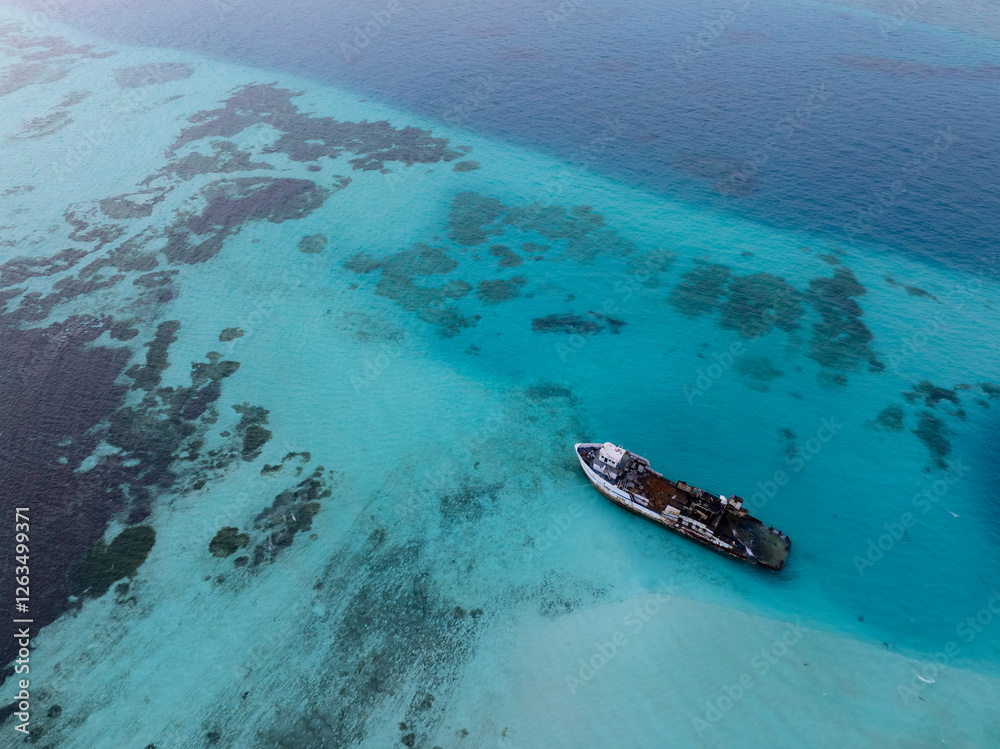Aerial view of a half sunken ship at Maldives, Indian ocean. Big rusty ship is on this photo in a lagoon.