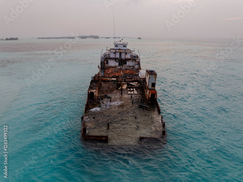 Obraz na płótnie Aerial view of a half sunken ship at Maldives, Indian ocean. Big rusty ship is on this photo in a lagoon. w salonie