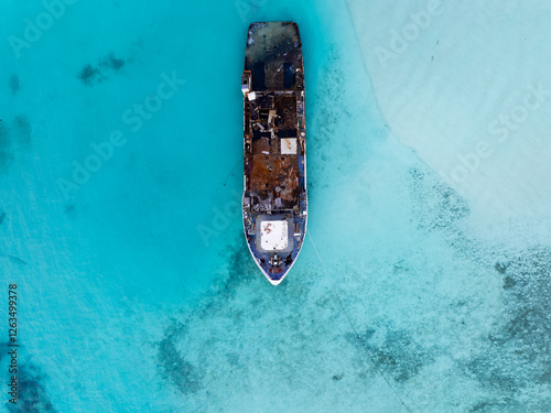 Obraz na płótnie Aerial view of a half sunken ship at Maldives, Indian ocean. Big rusty ship is on this photo in a lagoon. w salonie