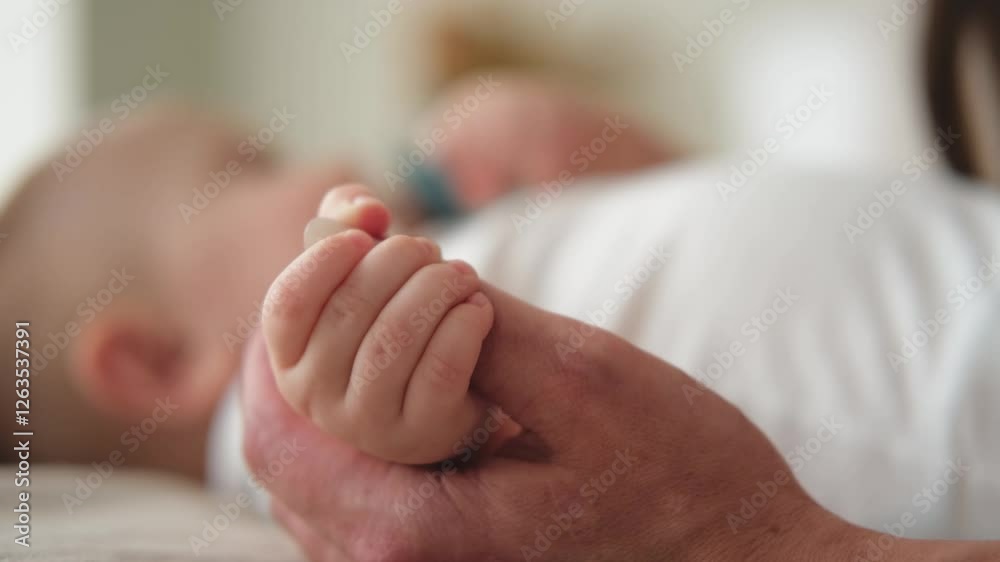 Happy family. Tiny newborn infant baby little hand on mother hand palm. Newborn baby holding parent finger after birth. Mom baby at home. Support protection of new life. Handle with care Happy family. Tiny newborn infant baby little hand on mother hand palm. Newborn baby holding parent finger after birth. Mom baby at home. Support protection of new life. Handle with care