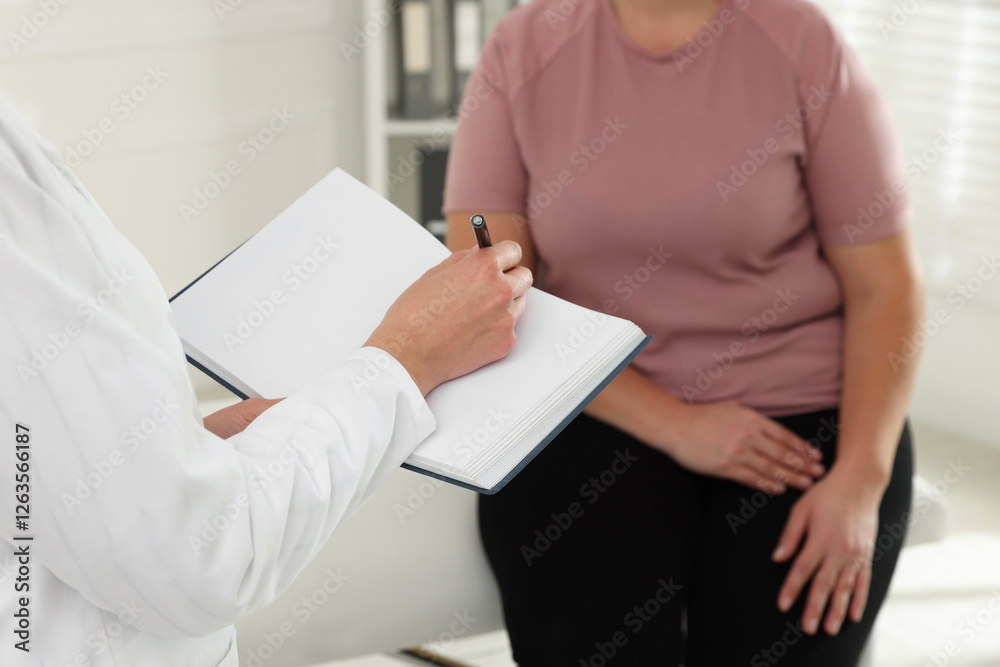 Nutritionist with notebook giving recommendations to overweight woman in hospital, closeup Nutritionist with notebook giving recommendations to overweight woman in hospital, closeup