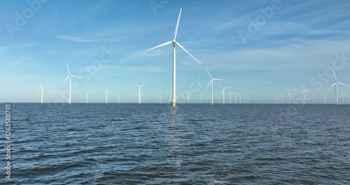 Wind turbines at the Afsluitdijk on water, converts the kinetic energy of wind into sustainable electrical energy, wind farms, renewable energy in The Netherlands.