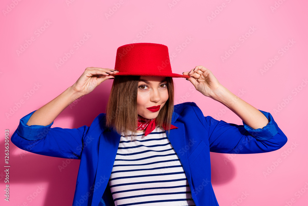 Φωτογραφία Young woman in elegant blue jacket and red hat posing against pink background, highlighting trendy fashion and modern lifestyle with charm