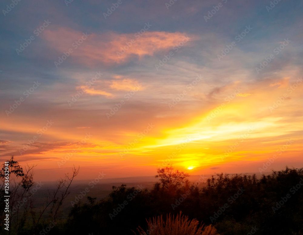 Fototapeta premium Atardecer sobre la montaña, con cielo naranja, amarillo y azul