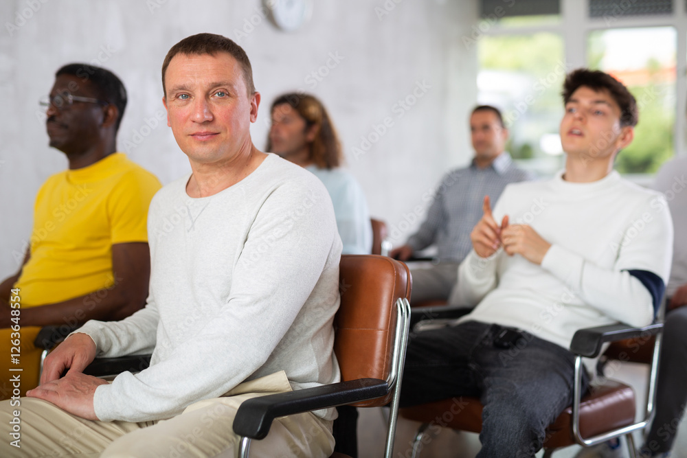 Portrait of a man sitting in a chair during a conference on same-sex relationships Portrait of a man sitting in a chair during a conference on same-sex relationships