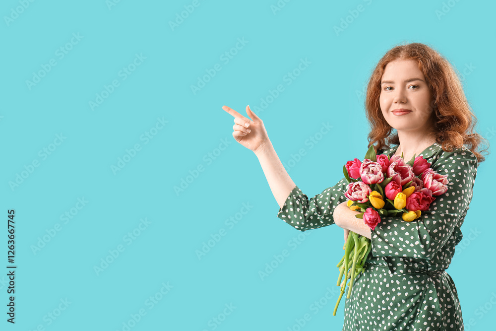 Young woman with bouquet of beautiful tulips pointing at something on blue background. International Women's Day Young woman with bouquet of beautiful tulips pointing at something on blue background. International Women's Day