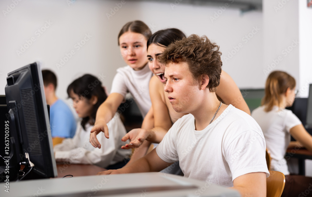 Multinational young students group working and emotionally discussing together in college computer room Multinational young students group working and emotionally discussing together in college computer room
