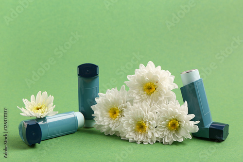 Modern inhalers and chrysanthemum flowers on green background photo