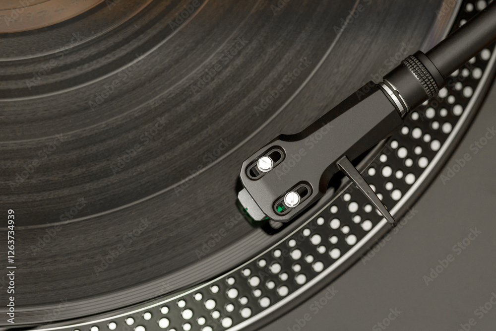 Giradischi, vista sulla testina. Disco musicale in vinile di colore nero.
