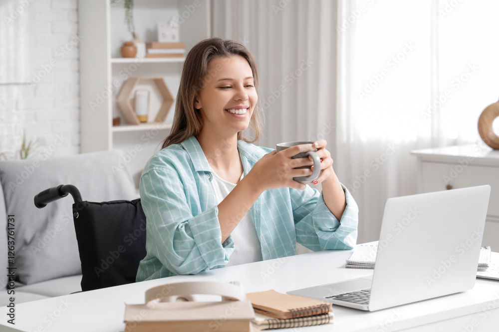 Young woman in wheelchair with cup of coffee near table at home Young woman in wheelchair with cup of coffee near table at home