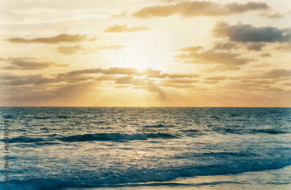 Fototapeta premium Sun rays breaking through the clouds over the sea