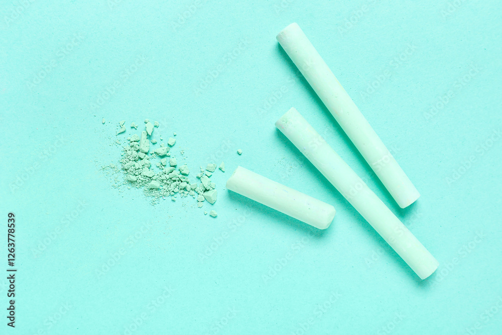 Green chalks with crushed pigment on turquoise background Green chalks with crushed pigment on turquoise background