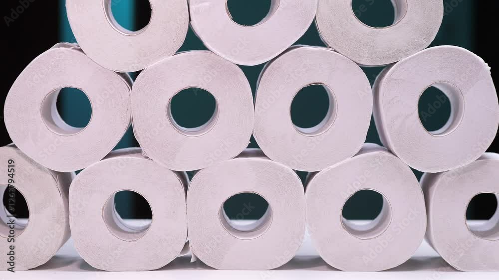 Stack of toilet paper rolls forming a pyramid on a white surface Stack of toilet paper rolls forming a pyramid on a white surface