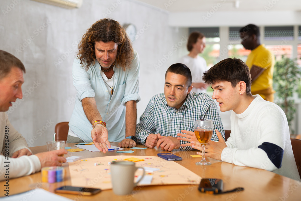 Group of active men play board games during a friendly meeting Group of active men play board games during a friendly meeting