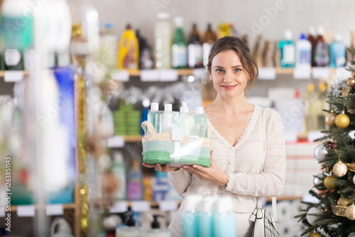 Wallpaper Mural Woman client chooses gift set of shower cosmetics. Buyer examines presentation set of samples of shampoo and shower gel, and related products packaged. Client buy X Mas gift cosmetic set. Torontodigital.ca