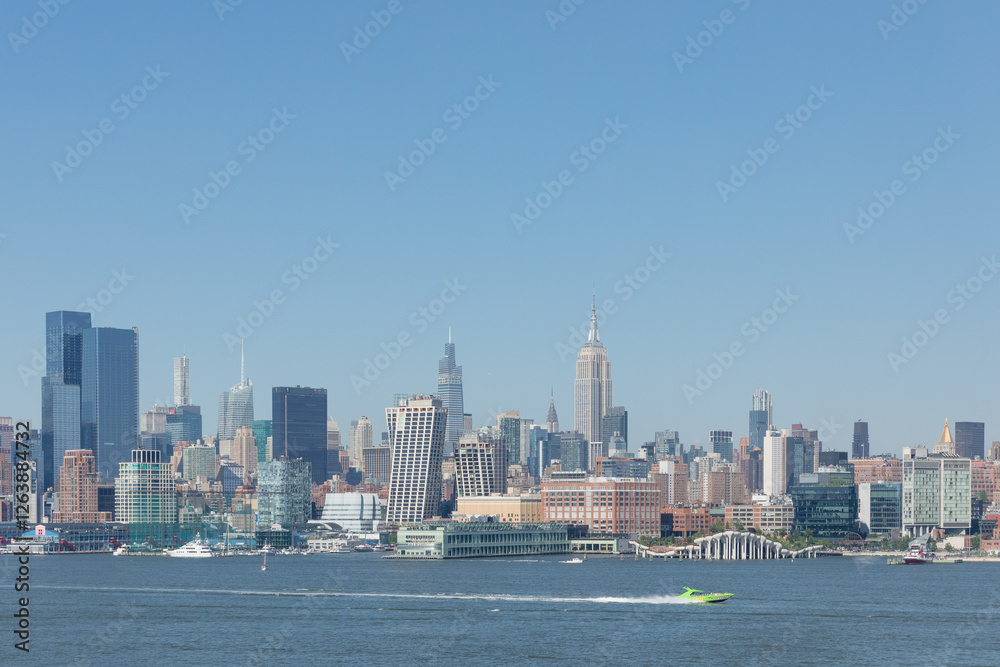 Obraz premium Iconic Manhattan skyline with the Empire State Building under clear blue skies during daytime