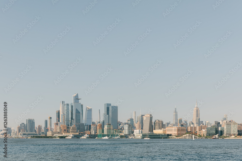 City skyline viewed from the water during a clear day with boats visible on the horizon