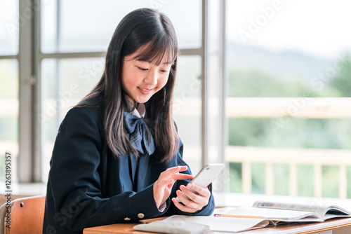 学校の教室でスマホを使ってオンライン授業を受ける小学生・中学生・高校生（ICT教育）
