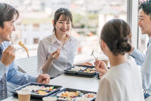 社員食堂でランチ・仕出し弁当・デリバリー・ケータリングの弁当を食べる男女（福利厚生）
