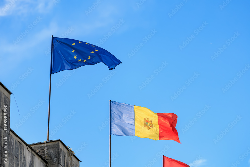 European union and moldovan flags waving against clear blue sky