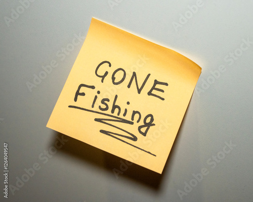 A yellow sticky note with Gone Fishing written in bold letters 
