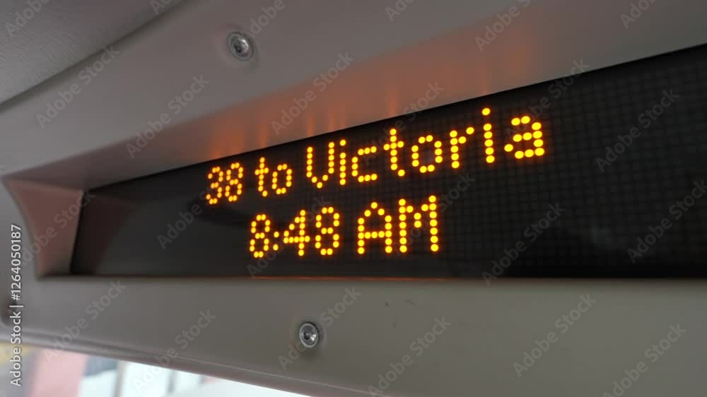 A digital display inside a city bus shows the route 38 to Victoria at 8:48 AM, This technology enhances the commuting experience by offering real-time updates on the route and schedule. A digital display inside a city bus shows the route 38 to Victoria at 8:48 AM, This technology enhances the commuting experience by offering real-time updates on the route and schedule.