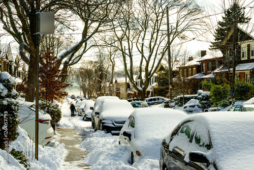 Photography A snow filled residential street being shovelled out after a snow fall