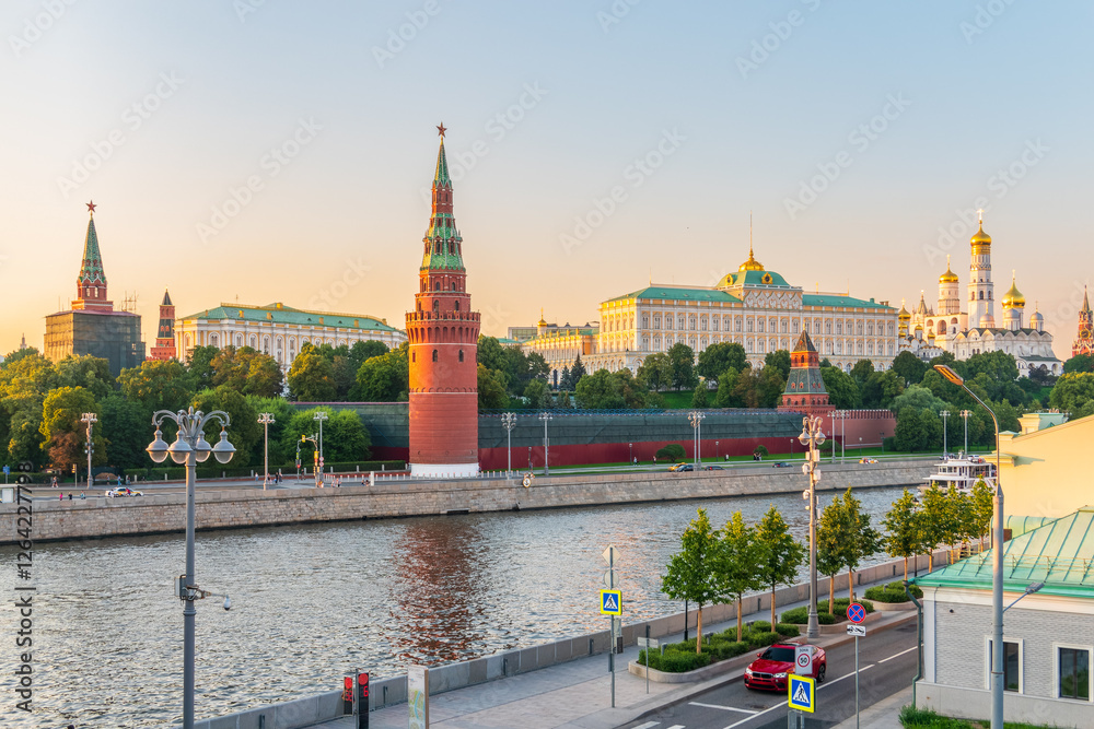 Obraz premium View of Kremlin with Vodovzvodnaya tower, Grand Kremlin Palace from repaired Bolshoy Kamenny Bridge in Moscow city on sunny summer day. Cruise ship sails on the Moscow river