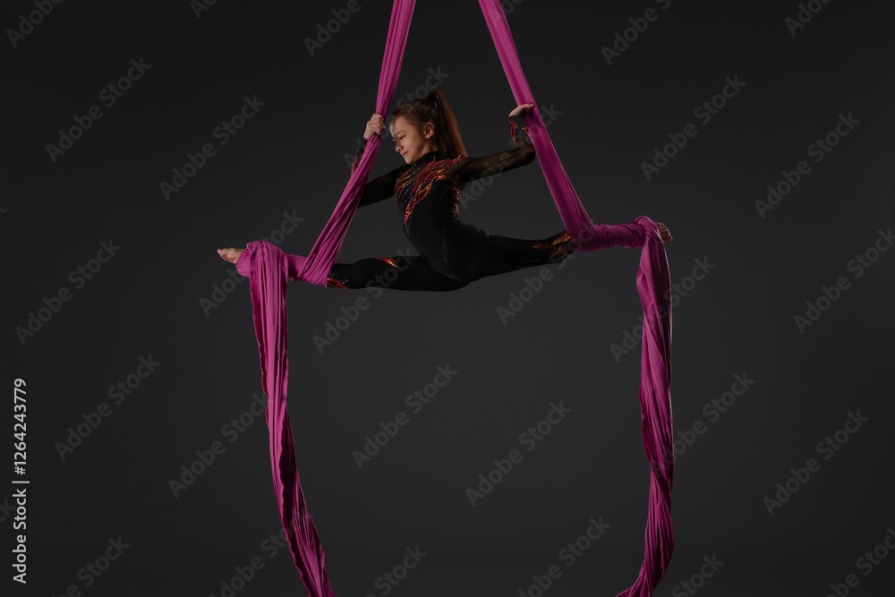 Girl performing an impressive aerial routine with pink fabric Girl performing an impressive aerial routine with pink fabric