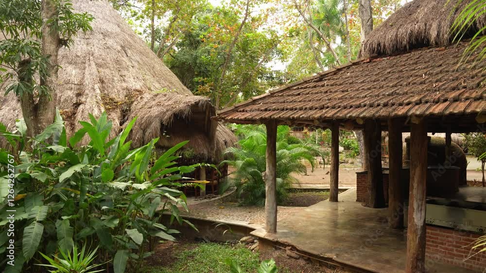 Traditional thatched-roof huts surrounded by lush tropical in a rustic eco-lodge in Yucatan, Mexico. Traditional thatched-roof huts surrounded by lush tropical in a rustic eco-lodge in Yucatan, Mexico.