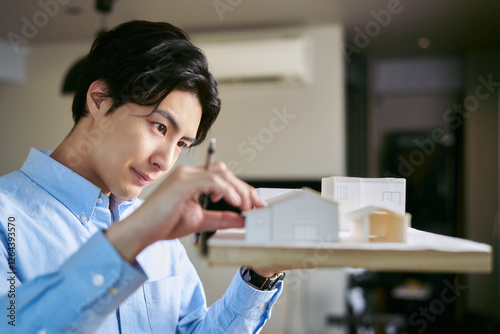 事務所で建物の模型を作って住環境を考えた建築を設計する建築家の男性