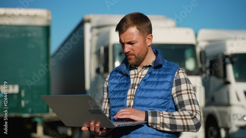 Logistics worker managing fleet operations on laptop