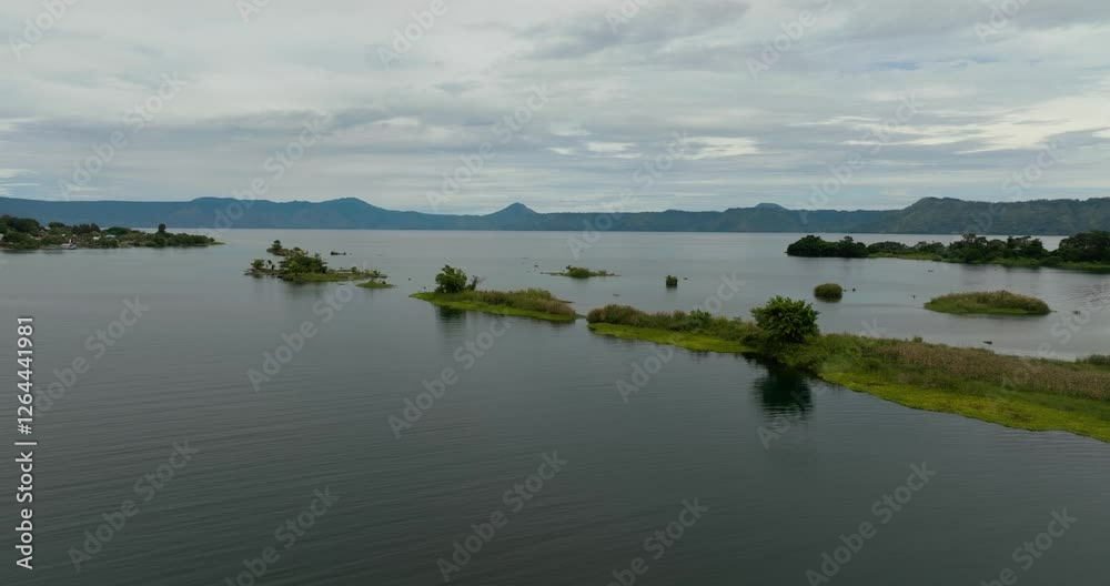 Aerial drone of beautiful Lake Toba and an island with palm trees. Samosir, Pulau Toba. Sumatra, Indonesia. Aerial drone of beautiful Lake Toba and an island with palm trees. Samosir, Pulau Toba. Sumatra, Indonesia.