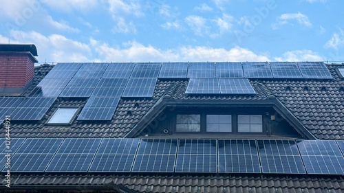 Solar panels on residential roof under blue sky, promoting renewable energy, eco-friendly technology, green living