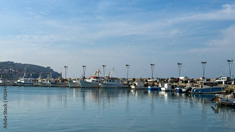 Peaceful seaside marina with docked fishing boats, reflecting calm coastal life, perfect for summer getaways Peaceful seaside marina with docked fishing boats, reflecting calm coastal life, perfect for summer getaways