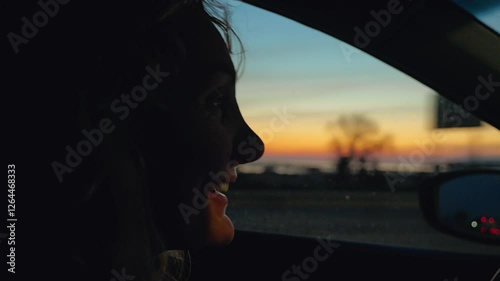 Wallpaper Mural Close-up of a girl driving a car against the backdrop of sunset over the sea. A serene twilight scene from inside the car, showing the gradient of warm colors in the sky as daylight fades Torontodigital.ca