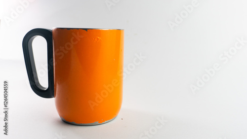 an orange cup whose paint has started to peel off, isolated on white