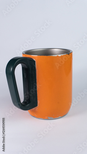 an orange cup whose paint has started to peel off, isolated on white