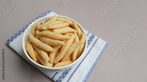 Crunchy Cheese Stick or Cheese Cork Eggs or Telur Gabus Keju or Widaran or Bidaran Keju is an Indonesian traditional snack. It's savory, salty and crispy. Served on a bowl. Grey background photo