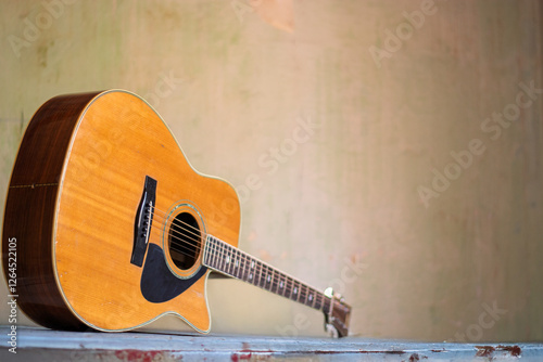 an old classical guitar leaning against an old table in an old house