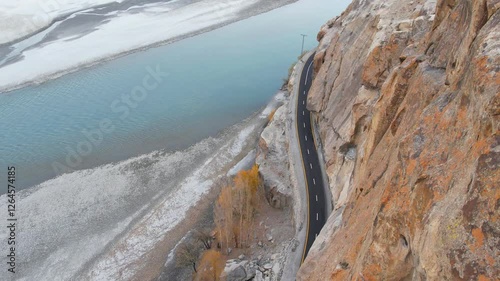 Wallpaper Mural Aerial top view of an asphalt road apassing through the cliff of rugged mountains wiith partially snowy landscape in SKardu, Pakistan. Torontodigital.ca