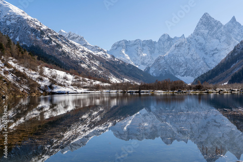 Dombay, Karachay-Cherkessia. Teberda National Park. Lake Tumanly-Gel or Tumanly-Kol (Misty Lake) is in valley of Gonachkhir River. Snowy peaks of Mount Chotcha are reflected in lake as in mirror. photo