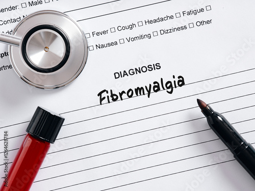 Doctor writing fibromyalgia diagnosis on patient's medical chart