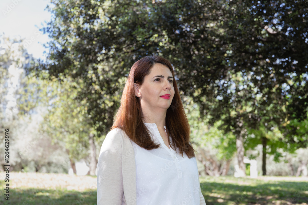 Middle-aged woman in a natural environment, dressed in neutral tones. Concept of serenity, balance and connection with nature Middle-aged woman in a natural environment, dressed in neutral tones. Concept of serenity, balance and connection with nature