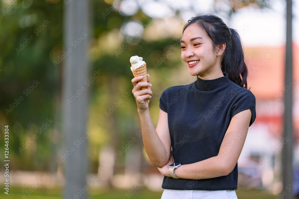 Smiling young asian woman holding an ice cream cone in a park, enjoying a sweet treat on a sunny day, wearing a smartwatch and casual clothes Smiling young asian woman holding an ice cream cone in a park, enjoying a sweet treat on a sunny day, wearing a smartwatch and casual clothes
