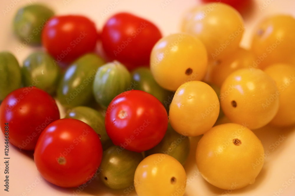 A variety of colorful tomatoes arranged on a clean white plate. A variety of colorful tomatoes arranged on a clean white plate.
