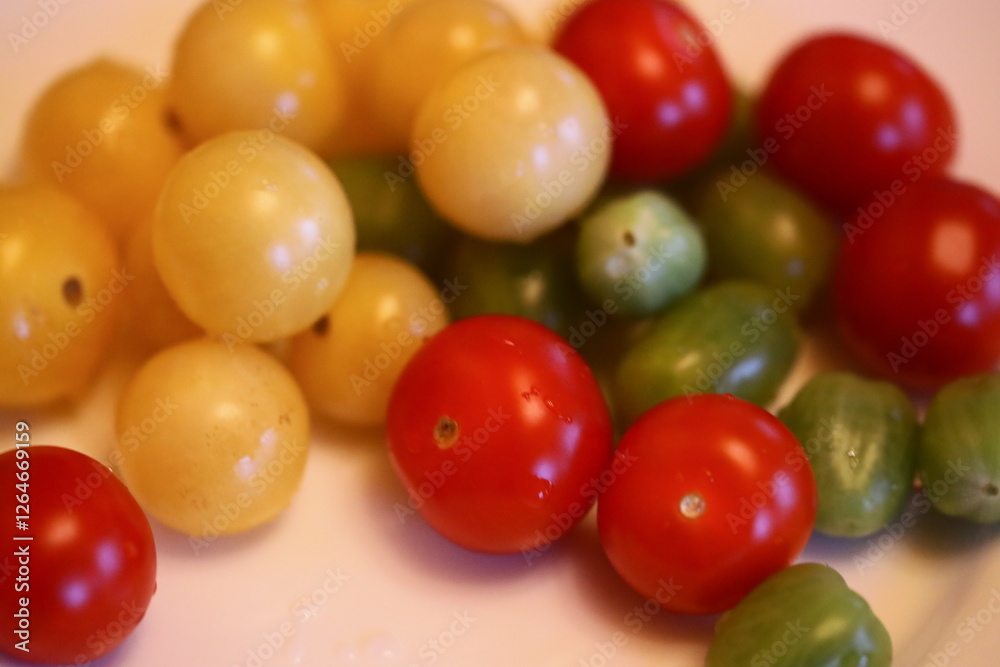 A selection of colorful tomatoes arranged on a white plate for display or use in various recipes. A selection of colorful tomatoes arranged on a white plate for display or use in various recipes.
