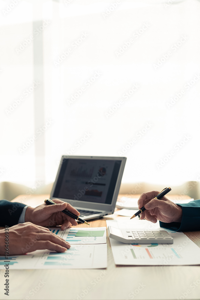 Fototapeta premium Business Colleagues team analyzes financial data at table in modern office about business strategy during discussion. There are financial charts and graphs on the table. Close-up vertical image