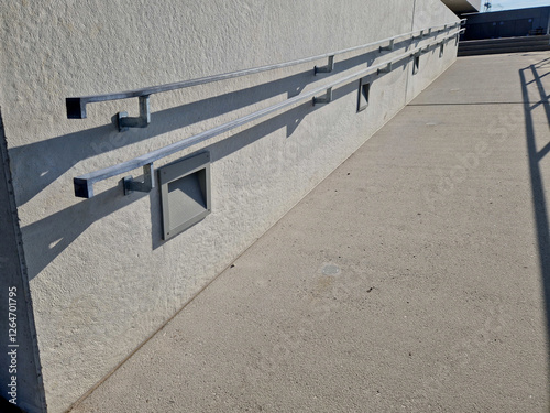 wheelchair ramp and stairs on the other side. height differences are tastefully and functionally solved by a retaining wall with a glass railing. city ​​stairs with recessed lights park lawn handlebar photo